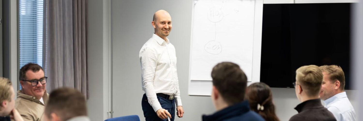 neuvottelutila, mies valkoisessa paidassa ja fläppitaulu